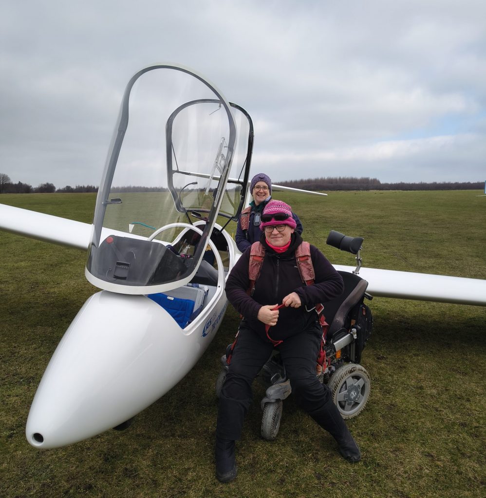 Photo of two female pilots getting into a two-seat glider to go flying.