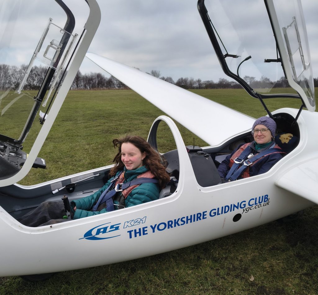 Photo of two female pilots sitting in a two-seat glider, ready to fly.